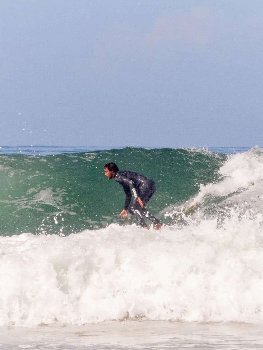 Surf coach demonstrating pop-up technique on the sand