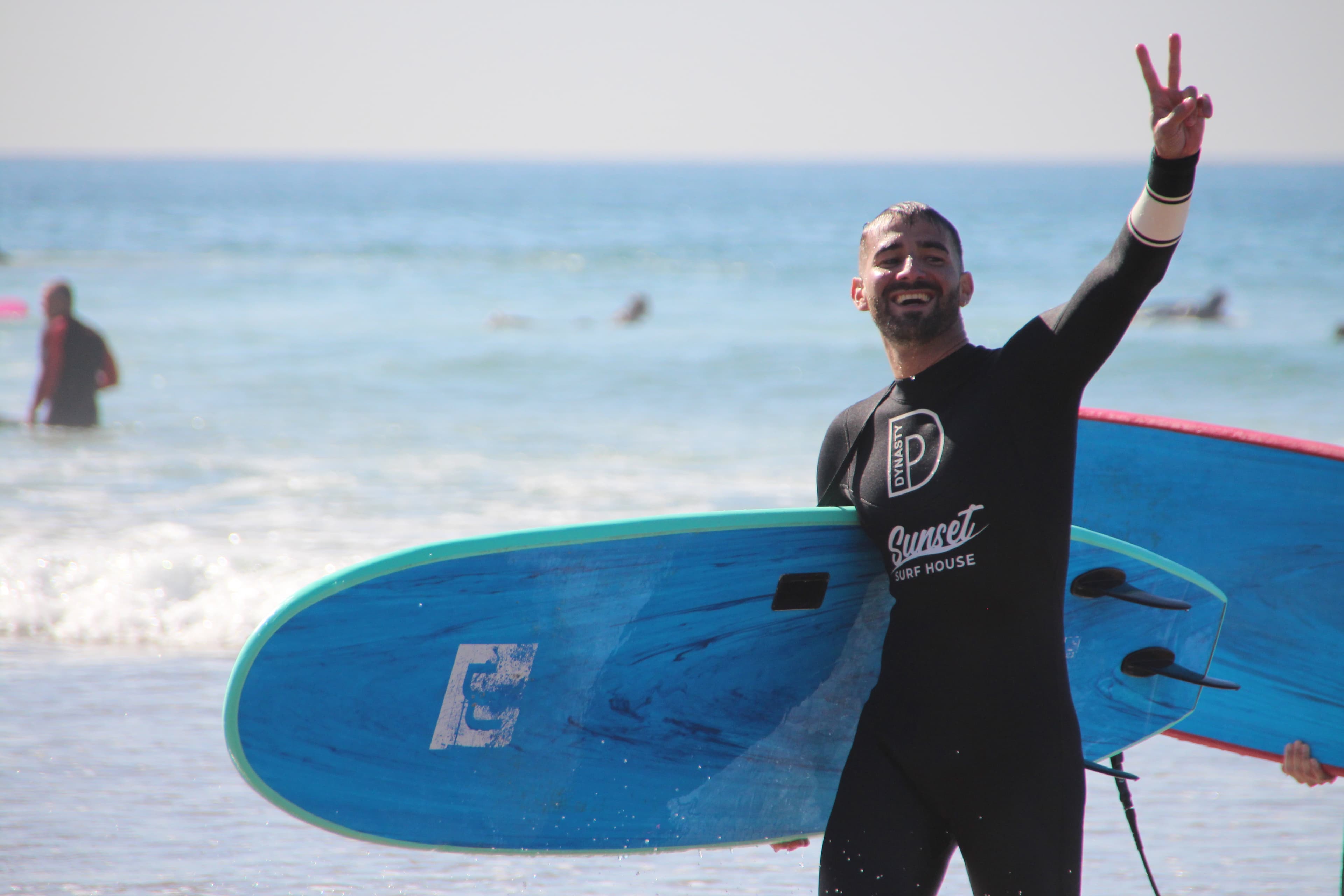 A surf coach briefing students on the beach before a lesson in Tamraght